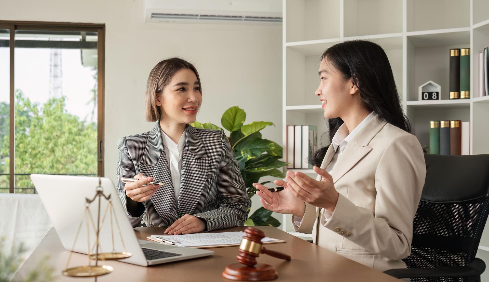 A young lawyer and businesswoman are discussing legal advice on signing a business contract. Insurance or financial contract signing
